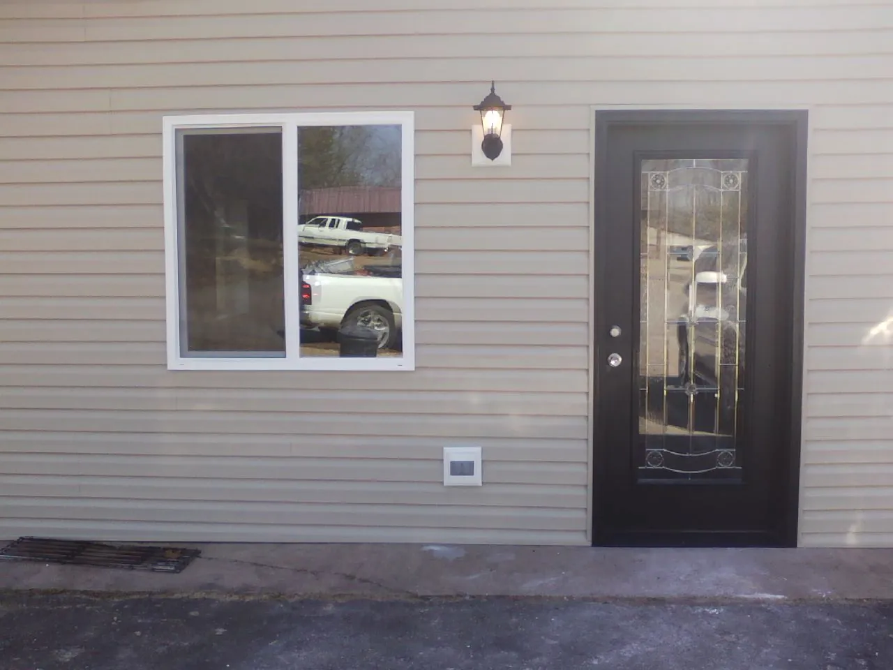 New siding, window and entry door on the side of an addition in Altona