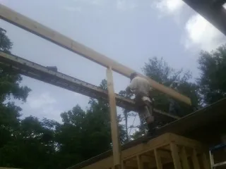 Carpenter setting a ridge beam over a new addition frame — Ice Dam Removal by Roofing Brothers in Altona
