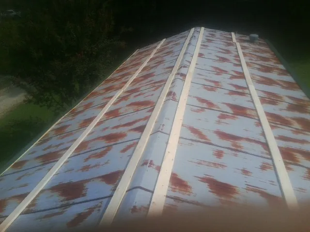 Rusted metal roof panels with new wood purlins before replacement — Storm Damage Roof Repair in Altona by Roofing Brothers